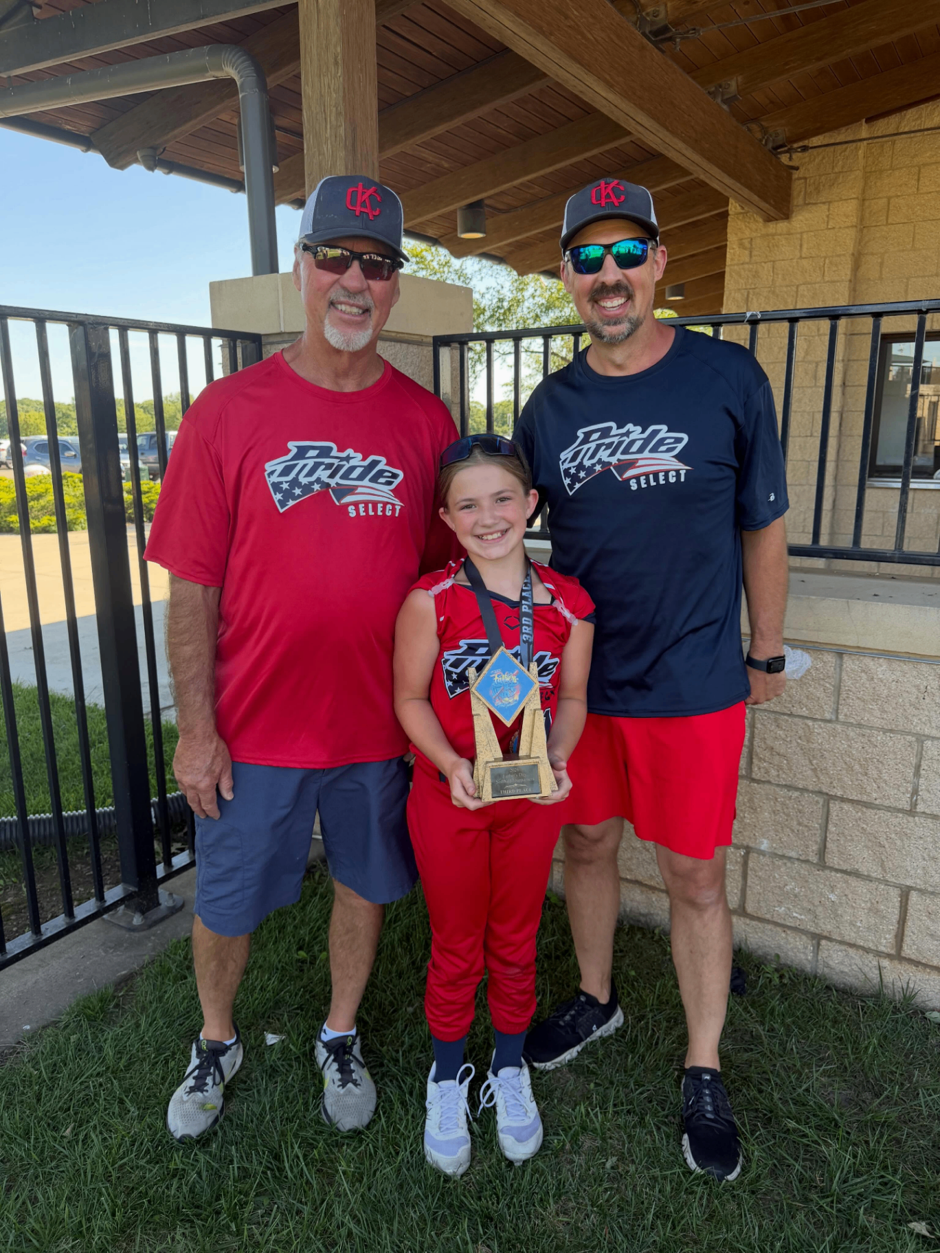 Pride athlete with coaches after receiving a tournament trophy