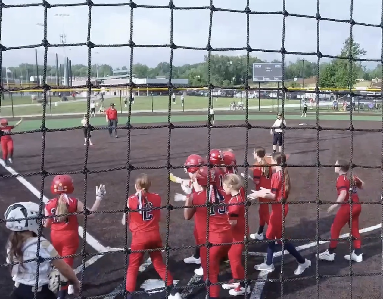 Pride athletes greeting a teammate at home plate after a home run